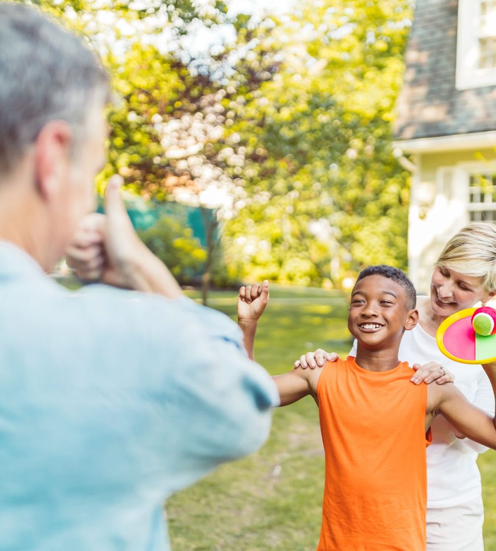 Family playing together in their backyard on a summer evening
